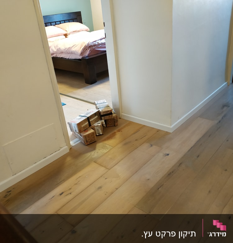 רצפת פרקט עץ עם קופסאות קרטון בכניסה לחדר